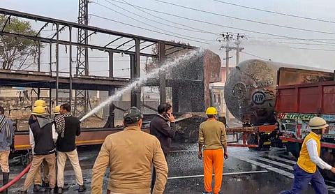 Firefighters extinguish the fire at the site of the accident after a truck loaded with a chemical collided with some other vehicles and caught fire on the Jaipur-Ajmer Highway, in Jaipur, Friday, 