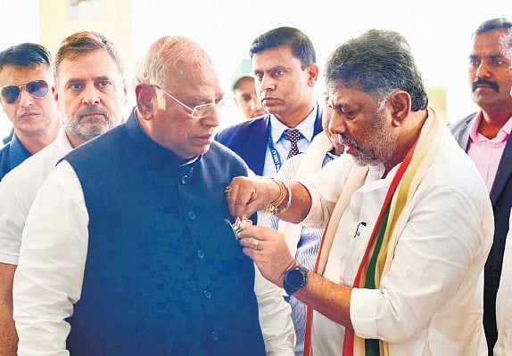 DK Shivakumar pins a Tricolour badge on Mallikarjun Kharge’s coat, as Rahul Gandhi looks on, in Belagavi on Thursday 