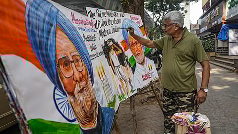 An art teacher paints portraits of former prime minister Manmohan Singh outside Gurukul School of Art as a tribute to the latter, who died last night, in Mumbai, Friday, Dec. 27, 2024.