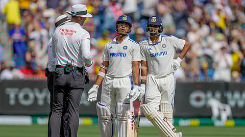 Yashasvi Jaiswal, center, speaks to umpires after being dismissed during play on the last day of the fourth cricket test between Australia and India at the Melbourne Cricket Ground.