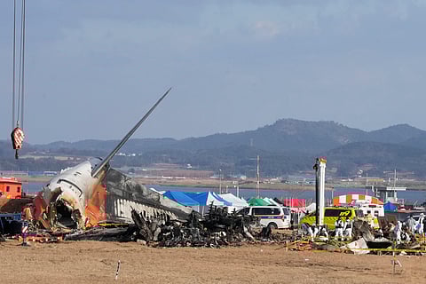 Rescue team members work at the site of a plane fire at Muan International Airport in Muan, South Korea on Monday.