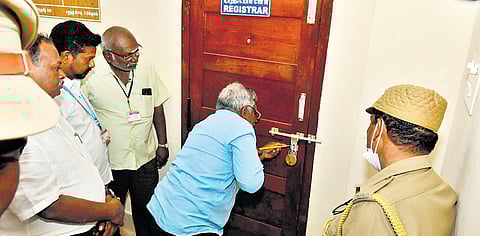 An official of Tamil University in Thanjavur on Monday breaking open the lock of the registrar’s room in the presence of police personnel 