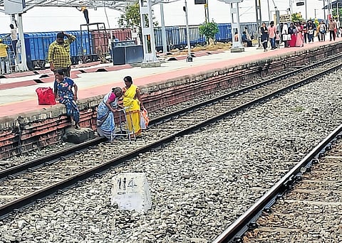Passengers cross the railway track to reach platform No.2 after sudden announcements by the Railway authorities at Miryalguda station on Wednesday