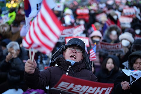 Supporters of impeached South Korean President Yoon Suk Yeol stage a rally to oppose a court having issued a warrant to detain Yoon, near the presidential residence in Seoul, South Korea, Friday, Jan. 3, 2025. The letters read "Oppose Impeachment."