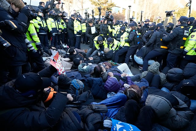 Supporters of impeached South Korean President Yoon Suk Yeol lie down on the ground as Yoon faces potential arrest after a court on Tuesday approved a warrant for his arrest, near the presidential residence in Seoul, South Korea