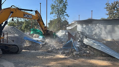 Bulldozer demolishing the "illegal" structure in the residential premises of accused.