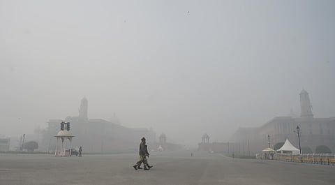 Soldiers walk at Vijay Ckowk on a cold and foggy winter morning.