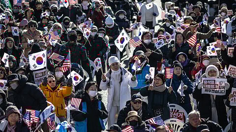 People wave US and South Korean flags during a rally in support of impeached South Korea president Yoon Suk Yeol in the Gwanghwamun area of Seoul on January 4, 2025.