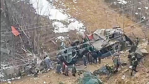 Security personnel and people gather near an overturned army vehicle skidded off the road and fell into a gorge near SK Payen, in Bandipora district, Jammu and Kashmir. 