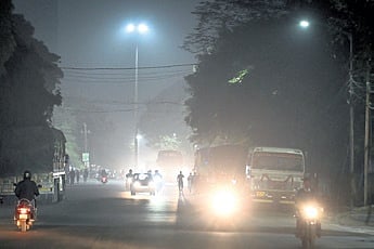 Commuters drive through a dusty road in Mancheswar on Sunday evening