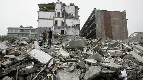 Residents try to use mobile phone to call their missing relatives as they search for survivors amonst the rubble of a collapsed building in Dujiangyan.
