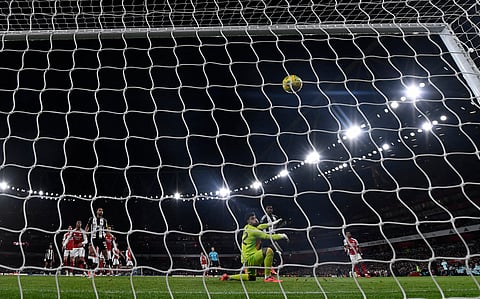Newcastle United's Swedish striker Alexander Isak scores the opening goal past Arsenal's Spanish goalkeeper David Raya during the English League Cup semi-final first leg football match between Arsenal and Newcastle United