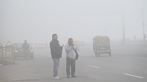 Commuters amid low visibility due to a very dense fog on a cold winter morning in New Delhi.