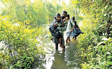 Saju Xavier carries his daughter Evania. Her siblings Sachin and Minsha are also seen.