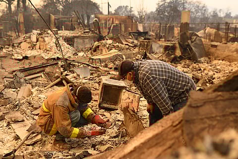 Robert Lara, left, looks for belongings along with his stepfather after the Eaton Fire burns in Altadena, Calif., Thursday, Jan. 9, 2025.