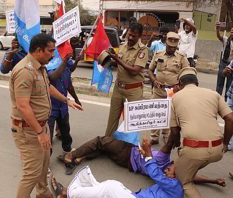 Police personnel detaining 5 persons of Aadhi Tamilar Party who threw beef meat at the BJPs Coimbatore district head office on Monday. 