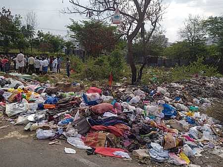 A picture of the burial ground in Pidamineri littered with heaps of trash