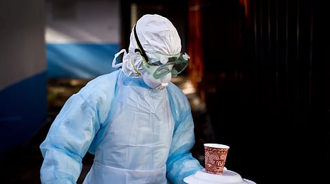 A medical worker carries a meal to an isolation tent housing a man being quarantined after coming into contact with a carrier of the Marburg Virus, at the Kenyatta National Hospital in Nairobi, Kenya, Oct. 8, 2014.