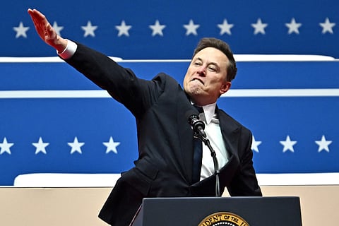 A Palestinian stands beside a trick that was torched in an attack by suspected Israeli settlers in the West Bank village of Jinsafut, Tuesday, Jan. 21, 2025.