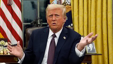 President Donald Trump talks to reporters as he signs executive orders in the Oval Office of the White House on Monday.