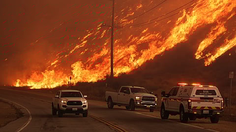 Fighter fighters monitor flames caused by the Hughes Fire along Castaic Lake in Castaic, Calif., Wednesday.