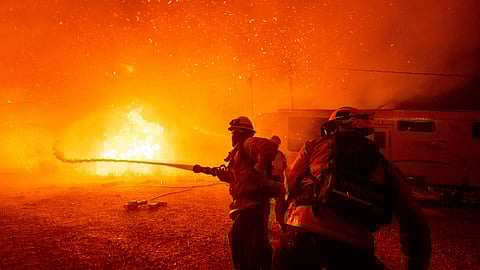Firefighters spray water on the Hughes Fire in Castaic, Calif., Wednesday, Jan. 22, 2025.