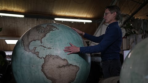 Peter Bellerby, the founder of Bellerby & Co. Globemakers, holds a globe at a studio in London, Tuesday, February 27, 2024.