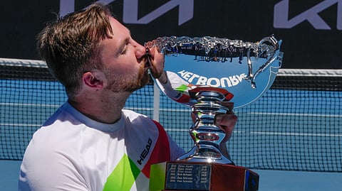 Sam Schroder of the Netherlands poses with his trophy after defeating compatriot Niels Vink in the men's quad wheelchair final at the Australian Open tennis championship in Melbourne, Australia, Saturday, Jan. 25, 2025. 