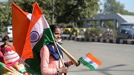 A vendor sells national flags at a roadside on the eve of the Republic Day celebrations in New Delhi on Saturday. 
