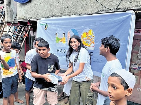 Vedika Balachandran and Ameya Uchil distribute footwear to the needy