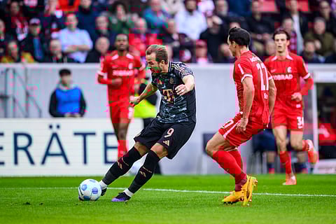 Munich's Harry Kane, left, scores during the Bundesliga soccer match between SC Freiburg and Bayern Munich at Europa-Park Stadium, Freiburg, Germany, Saturday Jan. 25, 2025.