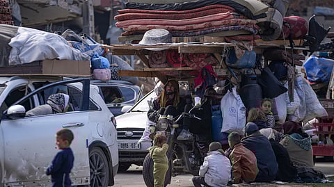 Displaced Palestinians with their belongings gather near a roadblock on Salah al-Din Street, as they wait to return to their homes in the northern part of the Gaza Strip, Sunday, Jan. 26, 2025, days after the ceasefire deal between Israel and Hamas came into effect.
