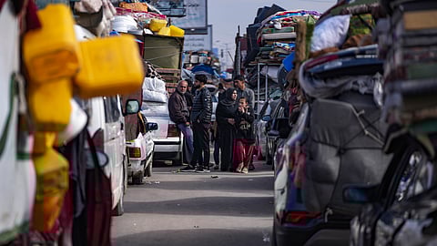 Displaced Palestinians with their belongings gather near a roadblock on Salah al-Din Street, as they wait to return to their homes in the northern part of the Gaza Strip on Sunday.