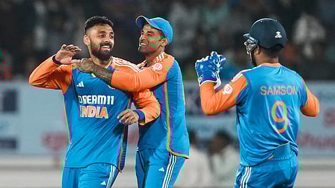 Varun Chakravarthy celebrates a wicket with his teammates in Rajkot 