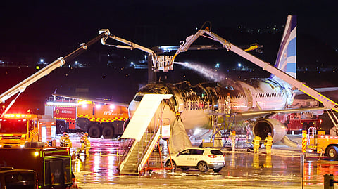 Firefighters work to extinguish a fire on an Air Busan airplane at Gimhae International Airport in Busan, South Korea.