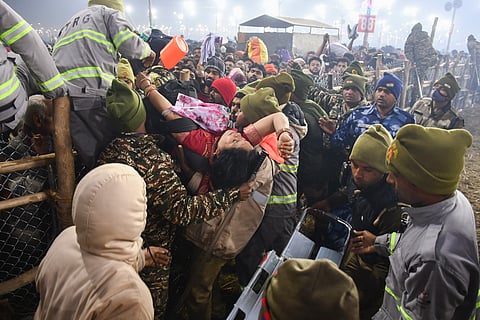 An injured woman being carried away by rescue personnel at the Mahakumbh (Photo | PTI)