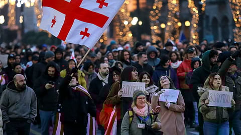 Demonstrators of hundreds of Georgian companies hold Georgian national flags rally as they went out into the streets suspending their work during an unprecedented three-hour nationwide strike in Tbilisi, Georgia, on Wednesday, Jan. 15, 2025. 