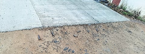 The concrete road cutting on the Ramamangalam-Piravom Road with protruding iron rods