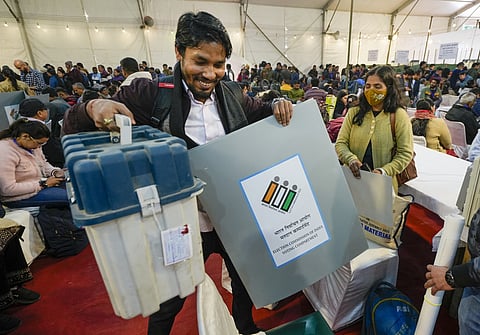 Polling officials collect election material at a distribution center on the eve of the Delhi Assembly elections at Gole Market (Photo | PTI)