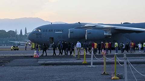 Migrants deported from the United States on a U.S. military plane walk down the runway at the Guatemalan Air Force Base