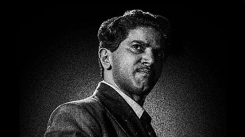 The black-and-white poster features a retro-styled Dulquer striking a serious, brooding pose.
