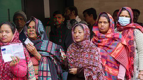 Voters stand in a queue to cast their votes at a polling station on Wednesday.