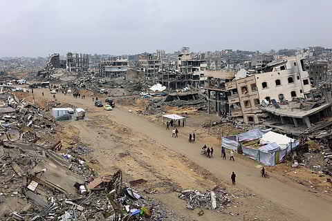 People walk amid collapsed buildings along Saftawi street in Jabalia in the northern Gaza Strip on February 5, 2025 during a ceasefire deal in the war between Israel and Hamas.