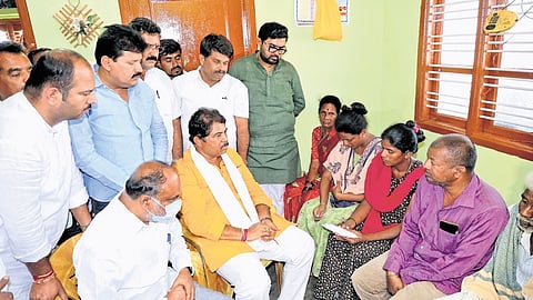 BJP leader R Ashoka meets the family of the woman and her son who died by suicide due to harassment from a microfinance firm, in Malavlli taluk on Thursday.