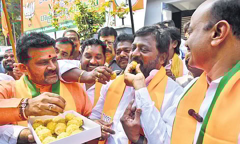 BJP activists celebrate the victory of the party in the Delhi Assembly elections, in Vijayawada on Saturday.