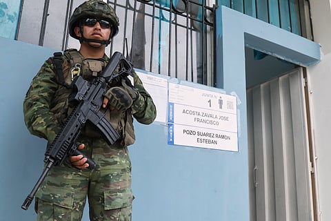A soldier guards a polling station during presidential elections in Olon, Ecuador, Sunday, Feb. 9, 2025.