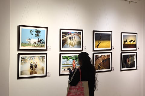 A visitor looks at the photographs displayed in the Galleria 2025 exhibit at the State Gallery of Art
