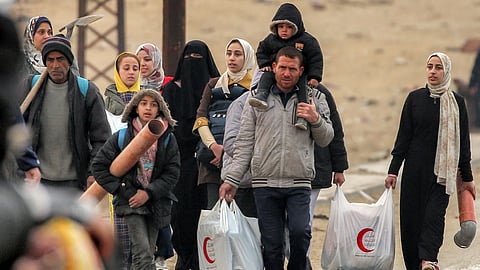 People walk with belongings along al-Rashid street between Gaza City and Nuseirat in the central Gaza Strip on February 10, 2025 as displaced people return home after the initial ceasefire in February.