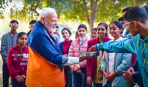 Prime Minister Narendra Modi distributes sweets among students while interacting with them on different aspects of stress-free exams under Pariksha Pe Charcha programme, in New Delhi.