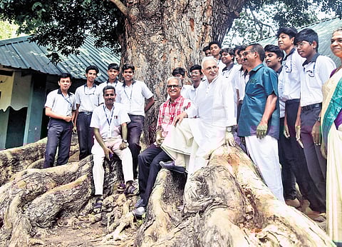Sri M at his alma mater, Government Model BHSS, Thycaud, with the students of the school under the shade of the iconic mahagony tree on the campus